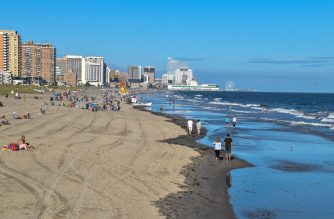 Ventnor City, New Jersey - September,2020: View from above a long beach at low tide from Ventnor City to Atlantic City showing large casino buildings in the distance