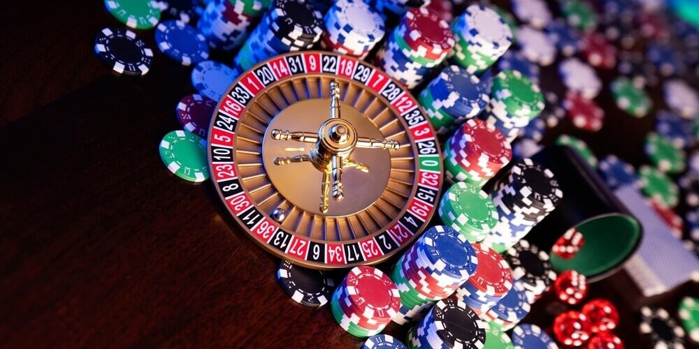 wheel of fortune progressive slot win Gambling and casino concept. Roulette wheel, poker chips, cards, dice, bokeh background.