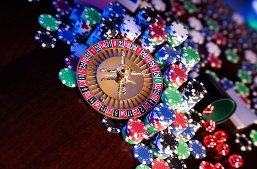 wheel of fortune progressive slot win Gambling and casino concept. Roulette wheel, poker chips, cards, dice, bokeh background.