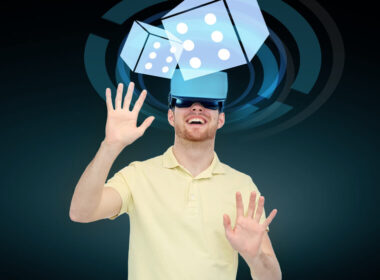 3d technology, virtual reality, cyberspace, entertainment and people concept - happy young man with virtual reality headset or 3d glasses playing game with casino dice projection over black background